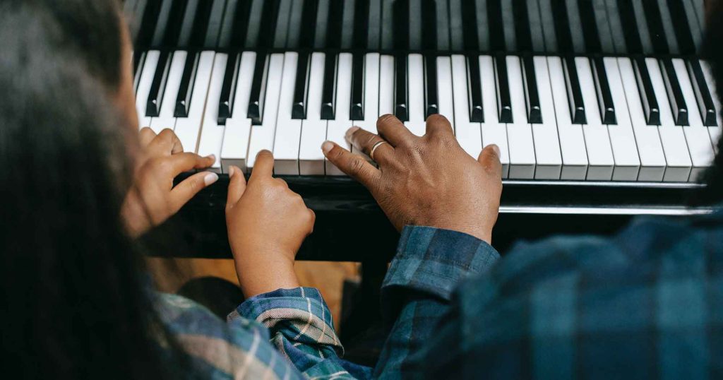 Student learns to play the piano during their music education