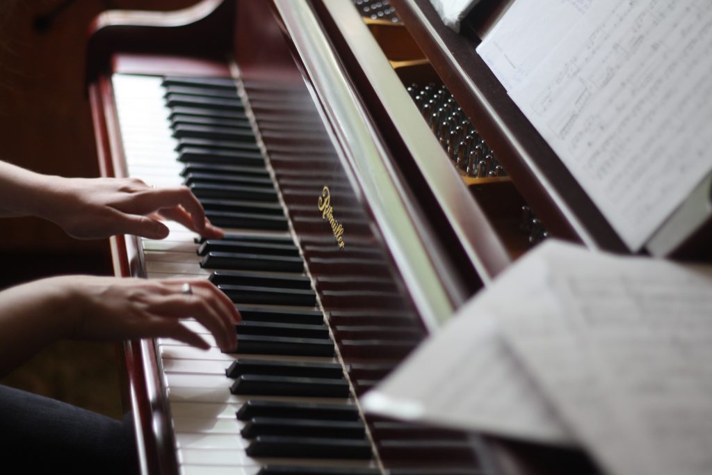 Musician playing the piano whilst preparing for a graded music examination