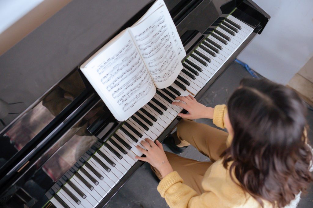 Image of woman playing piano and reading music